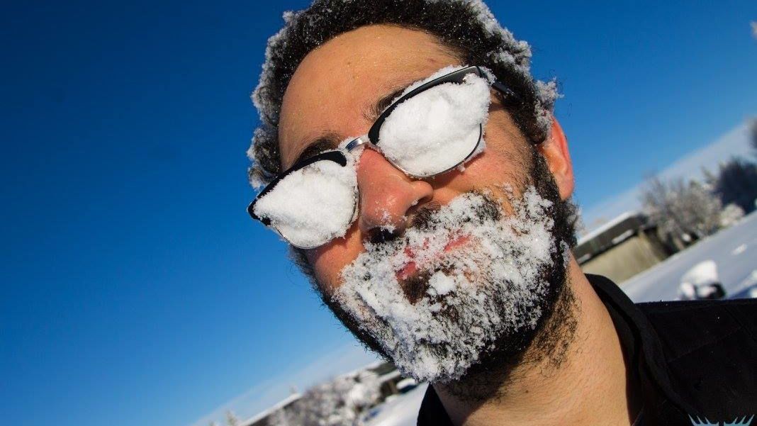 Guy with snow on the inside of his glasses looks into the camera